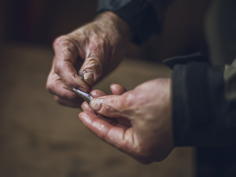 Close up of an angler's hands tying a lure to his fishing line
