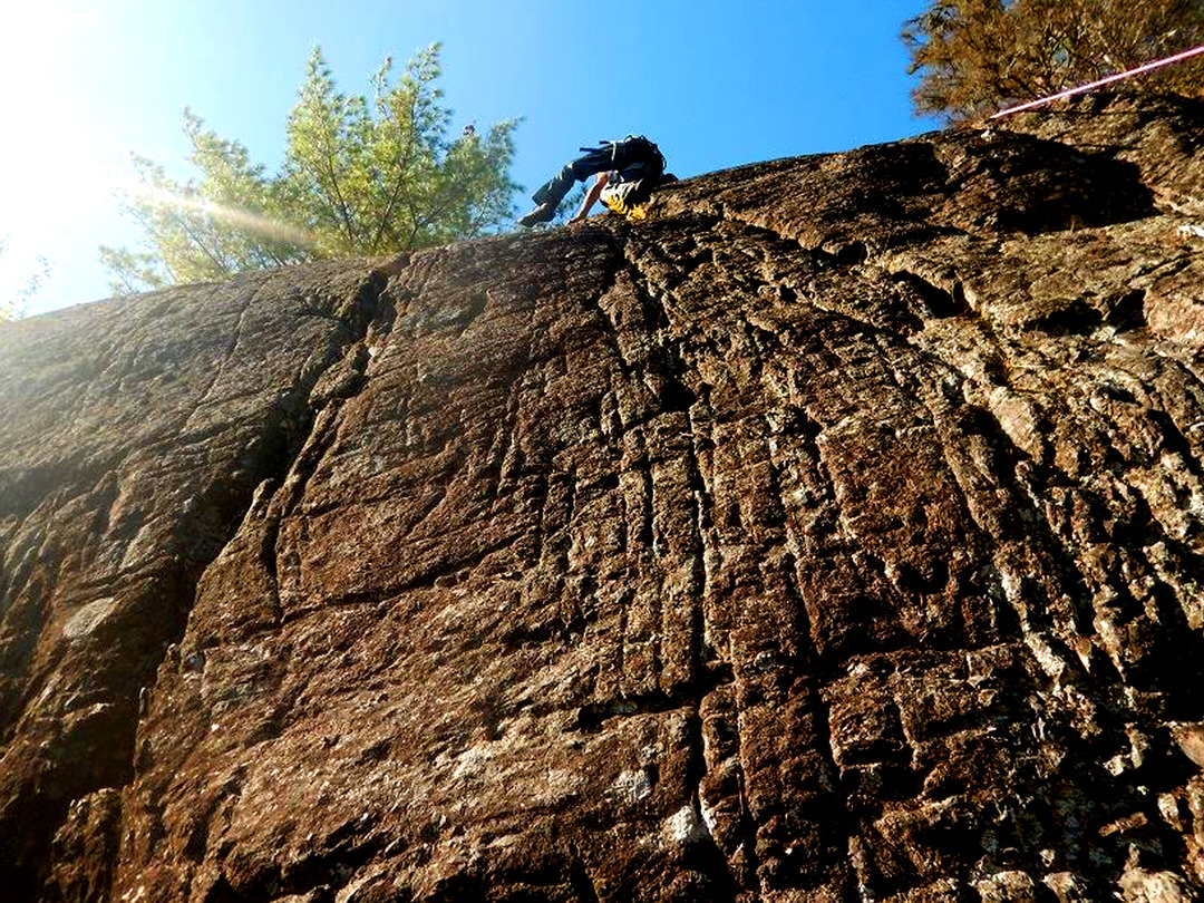 Man rock climbing a steep cliff