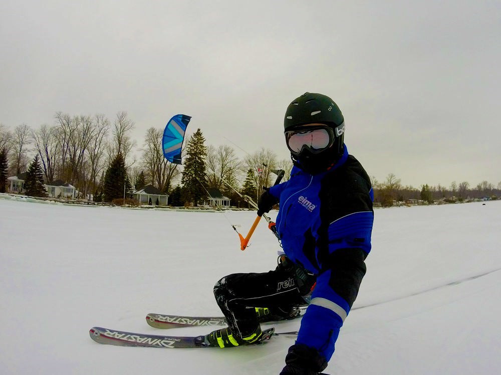 Eine Person beim Snowkiten auf einem zugefrorenen See