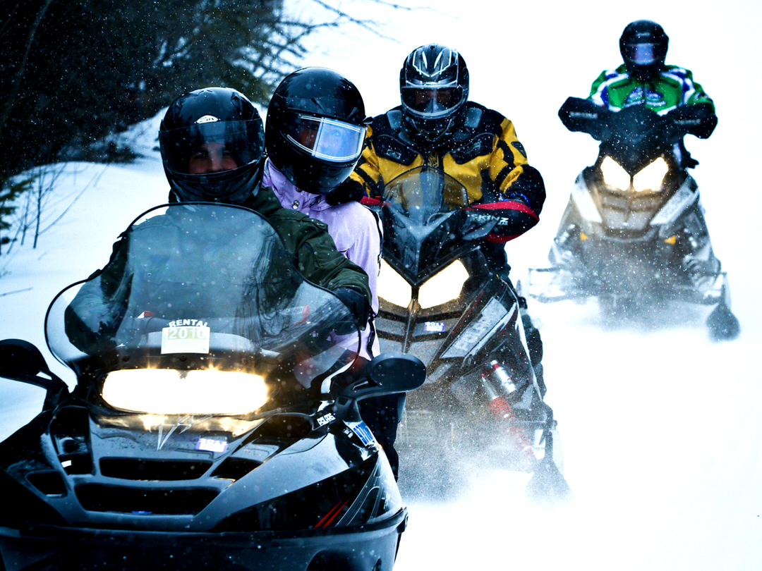 People riding on snowmobiles