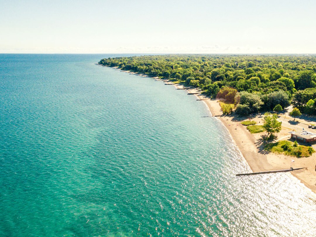 An aerial view of gorgeous blue green water and a long sandy beach