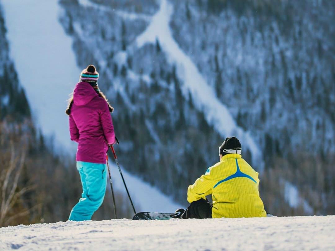 A couple pause to take in the scenic view on a ski hill