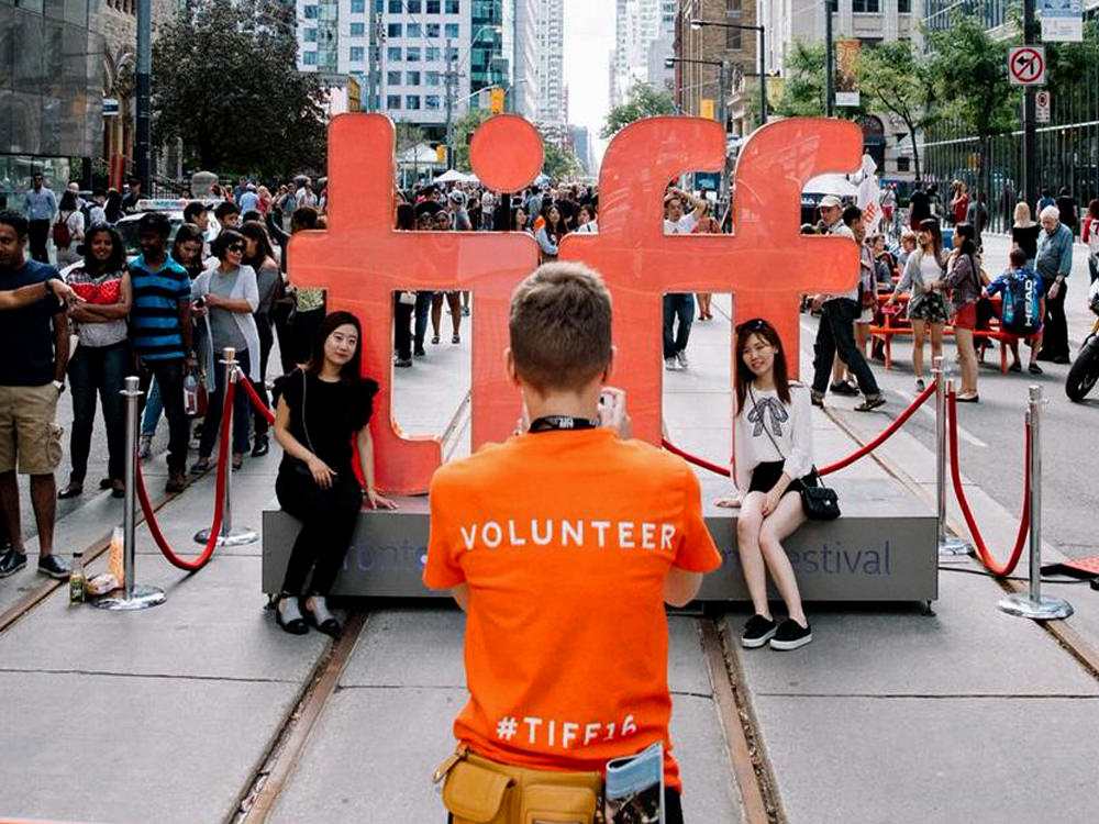 Un voluntario de TIFF toma una foto de los asistentes al festival.