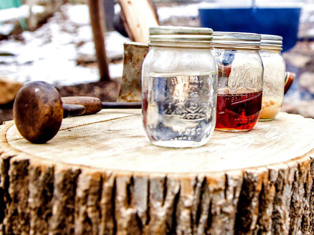 Trois pots de sirop d'érable s'asseoir sur une table en bois