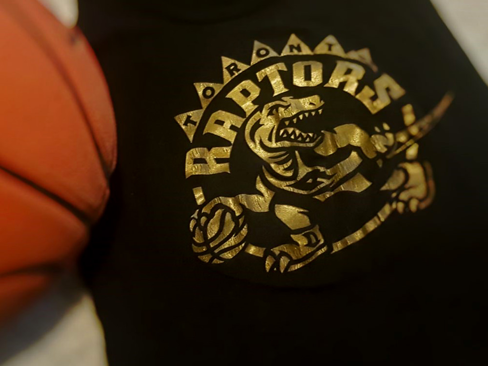 Ein Basketball und ein T-Shirt mit dem Logo der Toronto Raptors.