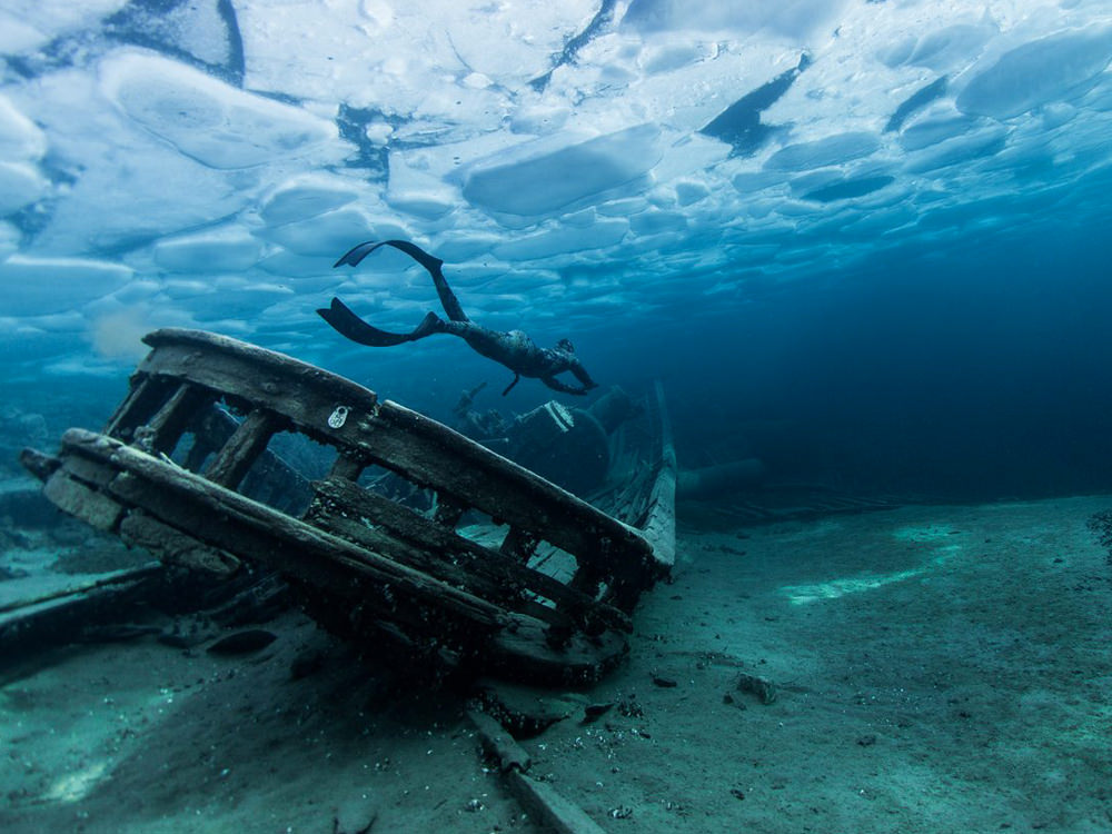 A person scuba dives around an underwater wreck in Ontario.
