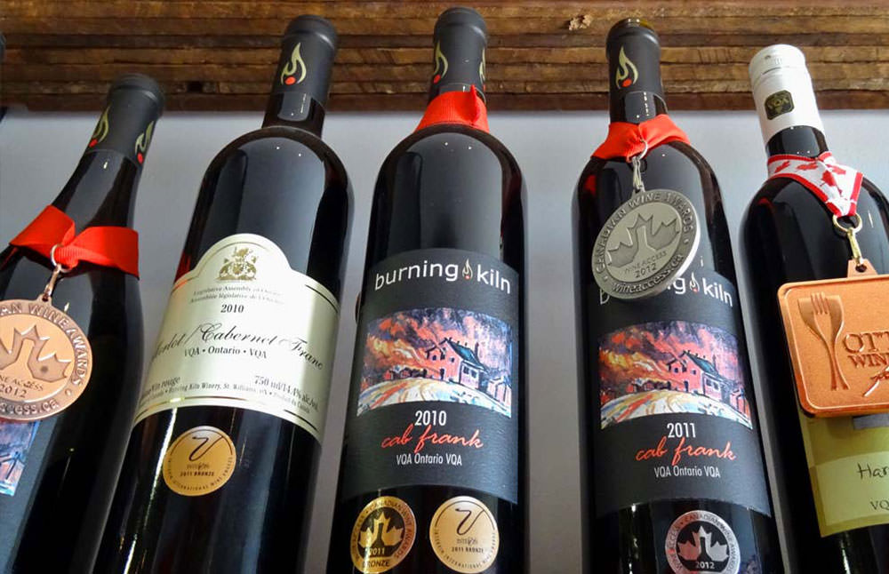 Una fila de vinos premiados en un estante