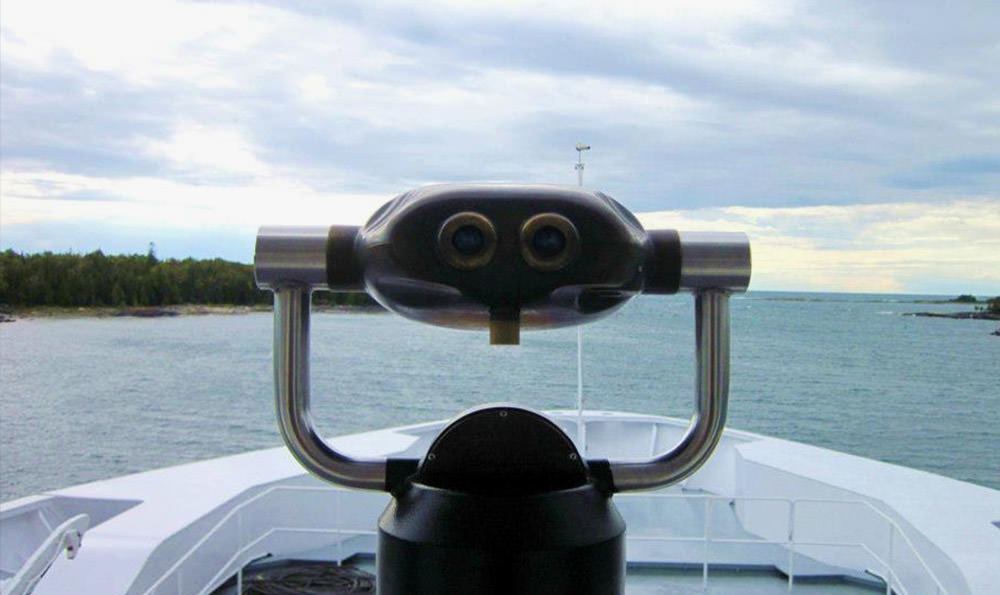 Un visor en la cubierta exterior de un ferry domina la costa y el lago más adelante.