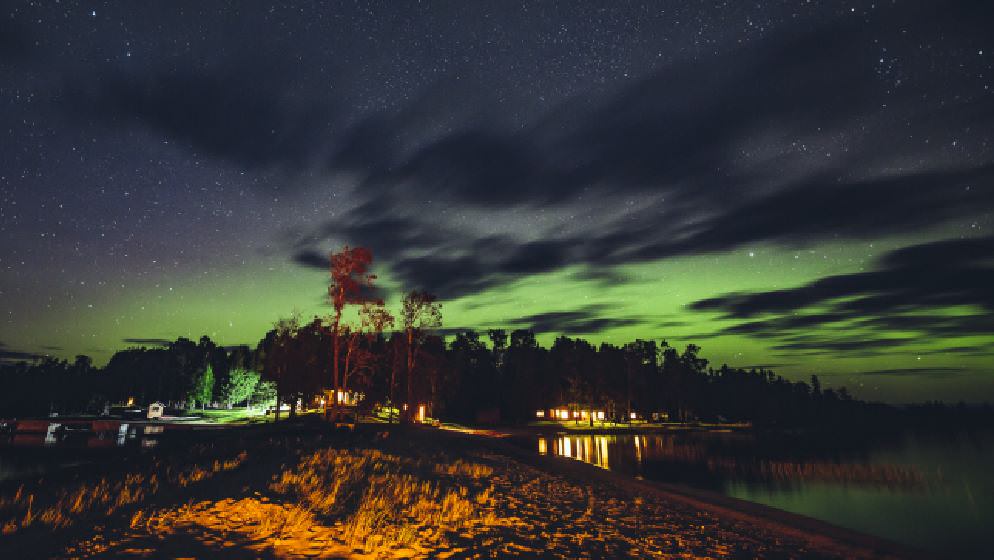 Grüne und blaue Farben des Nordlichts über einer kleinen Gemeinde im Norden Ontarios