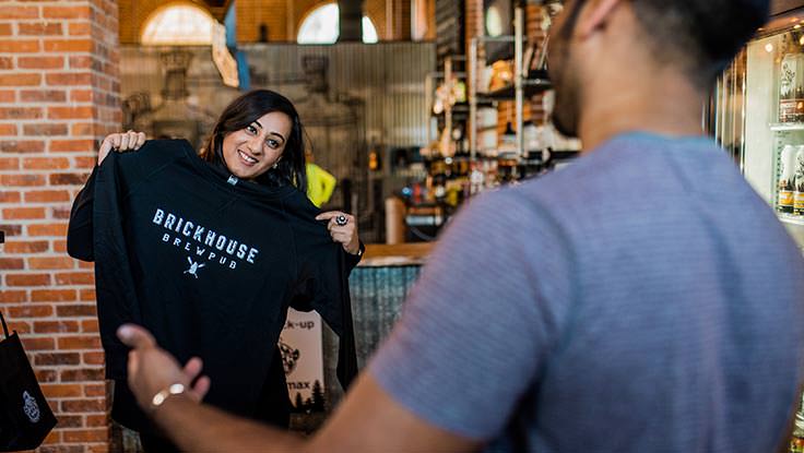 Una pareja comprando ropa en una cervecería local.
