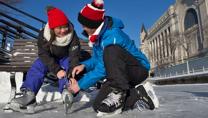 Un couple chausse ses patins en vue d'aller patiner sur le canal Rideau.