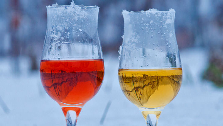 Ein Glas roter und weißer Eiswein im Schnee.
