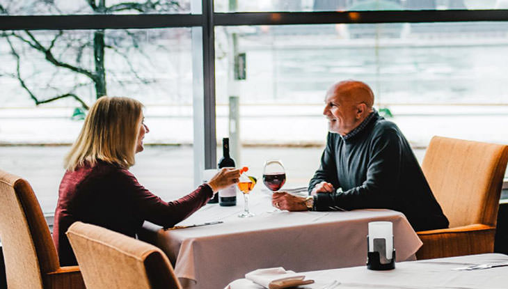 Un couple profite d'un bon repas et d'un verre ensemble dans un restaurant gastronomique.